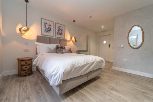 a bedroom with a large bed and a mirror at Bankton Rooms & Lodges in Livingston