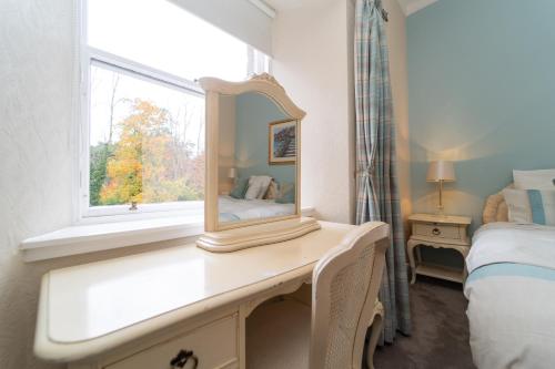 a mirror on a dresser in a bedroom with a window at Bankton Rooms & Lodges in Livingston