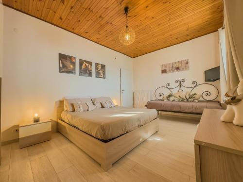 duża sypialnia z łóżkiem i kanapą w obiekcie Athena Sea front Apartment, Parking & Pool w mieście Lago Patria