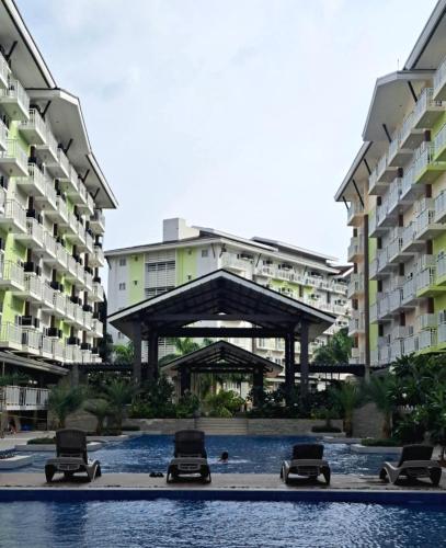 a group of apartment buildings with chairs in a courtyard at Cozy condo unit 5mins from Mactan Cebu Int'l Airport with Netflix in Mactan