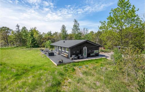 a log cabin in the middle of a field at Amazing Home In Ålbæk With Kitchen in Ålbæk
