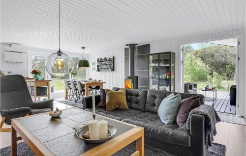 a living room with a couch and a table at Amazing Home In Ålbæk With Kitchen in Ålbæk