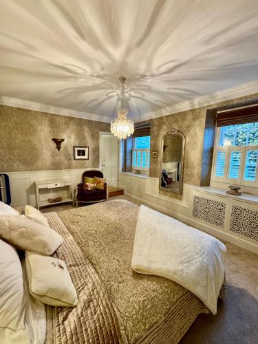 a bedroom with a large bed and a chandelier at Tuns House B&B in Eggleston