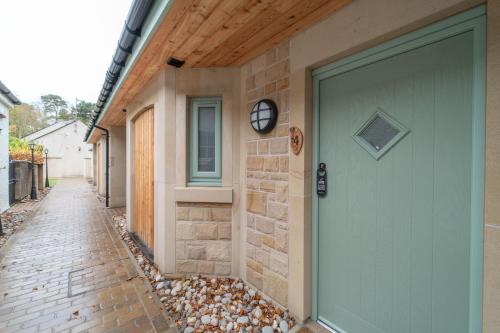 a house with a green door on a street at Bankton Rooms & Lodges in Livingston