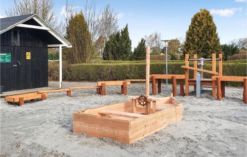 a playground with wooden benches and a wooden box at Beautiful Apartment In Væggerløse in Marielyst
