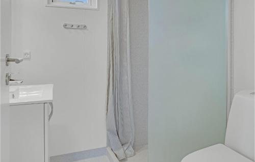 a white bathroom with a toilet and a sink at Beautiful Apartment In Væggerløse in Marielyst