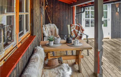 a porch of a house with a table and chairs at Nice Home In Tuddal With Kitchen in Tuddal