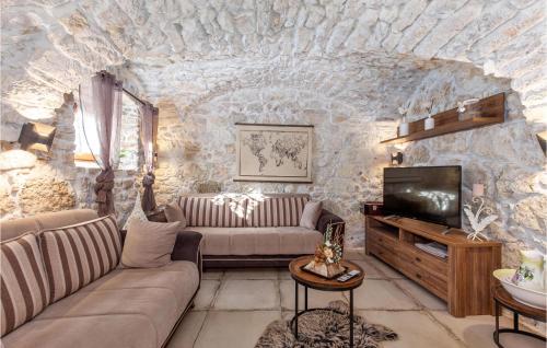 un salon avec un mur en pierre dans l'établissement Beautiful Home In Tribalj, à Tribalj