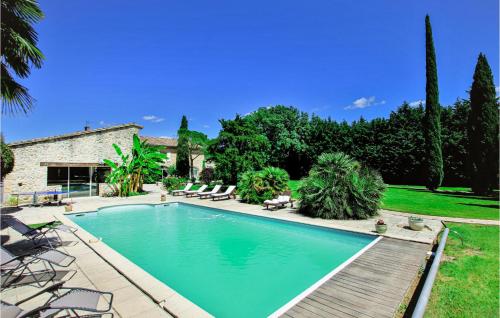 a swimming pool in a yard with chairs and a house at Beautiful Home In Loriol-Sur-Drôme in Loriol-sur-Drôme