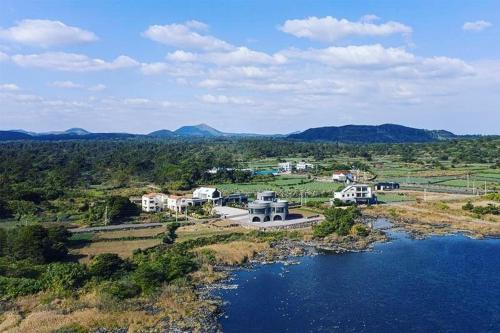 an aerial view of a house next to a body of water at Luxury Pool Villa, Villecot in Seogwipo
