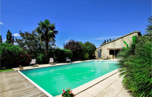 a swimming pool with two chairs and a building at Beautiful Home In Loriol-Sur-Drôme in Loriol-sur-Drôme
