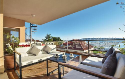 a balcony with couches and a view of a harbor at Three-Bedroom Apartment In Kastel Gomilica in Kaštela