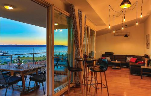 a living room with a table and a view of the ocean at Three-Bedroom Apartment In Kastel Gomilica in Kaštela