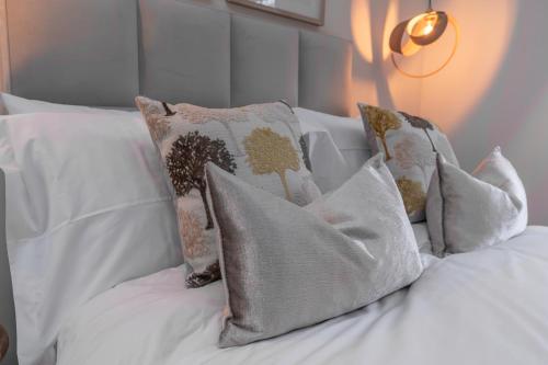 a white bed with several pillows on it at Bankton Rooms & Lodges in Livingston