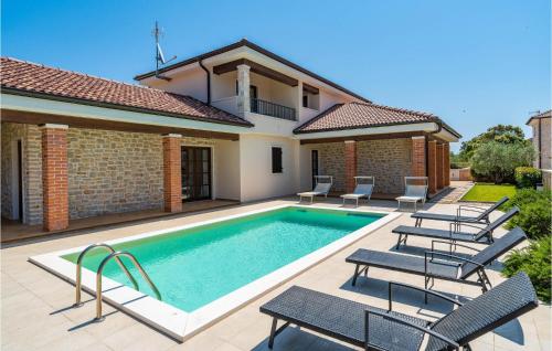 a swimming pool with chairs and a house at Four-Bedroom Holiday Home In Muline in Donje Selo