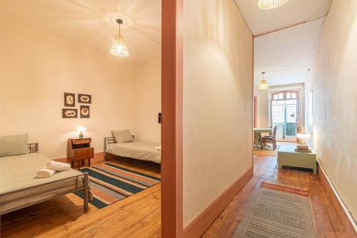 ein Wohnzimmer mit einem Bett und einem Sofa in einem Zimmer in der Unterkunft Casa do Alfaiate Séc XIX in Porto