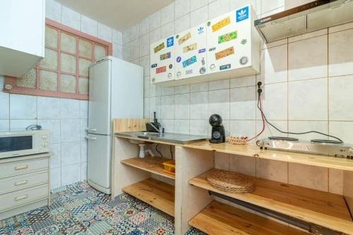 eine Küche mit Theke und Kühlschrank in der Unterkunft Casa do Alfaiate Séc XIX in Porto