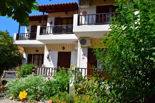 a building with balconies and flowers in front of it at Zaira Studios in Skala Eresou