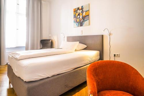 a bed in a room with a chair and a bedvisor at Boutique Hotel Kerlin in Berlin