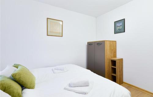 a bedroom with a white bed and a cabinet at Stunning Home In Ivanska in Ivanska