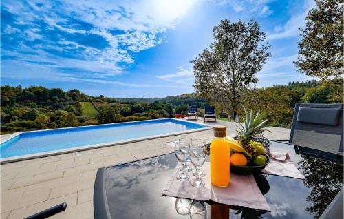 a table with a bowl of fruit on it next to a swimming pool at Beautiful Home In Pisarovina With Wi-Fi in Lipnica