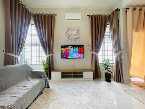 a living room with a couch and a tv at Glamstay Jitra Suasana Permai in Jitra