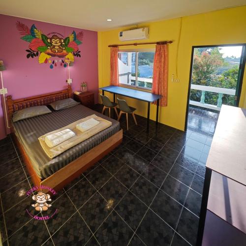 a bedroom with a bed and a desk in it at The Funky Monkey Hostel - 18 to 40 years old only in Haad Rin
