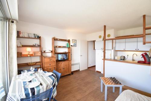un salon avec une table et une cuisine dans l'établissement Résidence Les Terrasses de Notre Dame, bel appartement avec vue sur l'entrée du port, à Capbreton