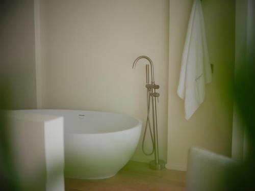 a white bath tub in a bathroom with a towel at Guilin Bonjour Boutique Hotel- Free pick up service over 3 nights in Guilin