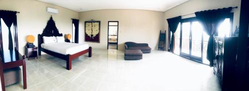 a bedroom with a bed and a chair and windows at Imaj Private Villas in Senggigi 