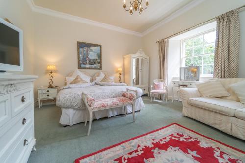 a bedroom with a bed and a couch and a tv at Bankton Rooms & Lodges in Livingston