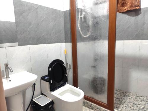 a bathroom with a toilet and a sink and a shower at TripleG's Transient Apartment House with FREE PARKING and CCTV in La Trinidad