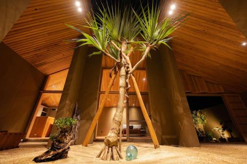 a palm tree in the middle of a room at Shiraho Villa Square Court in Ishigaki Island