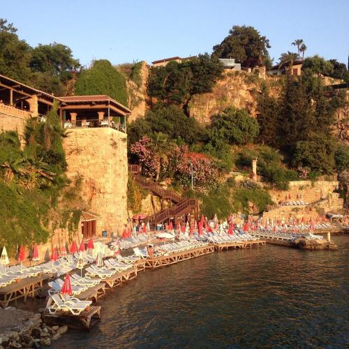 un montón de sillas y sombrillas en el agua en PRUVA İNN HoTEL, en Antalya