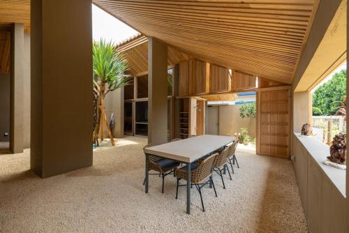 a patio with a table and chairs in a house at Shiraho Villa Square Court in Ishigaki Island