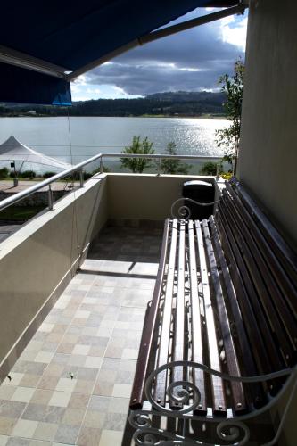 a bench on a balcony with a view of the water at Pontevedra Hotel Boutique in Paipa