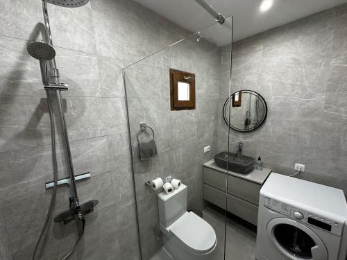 a bathroom with a toilet and a glass shower at Villa Bella Vista in Playa Blanca