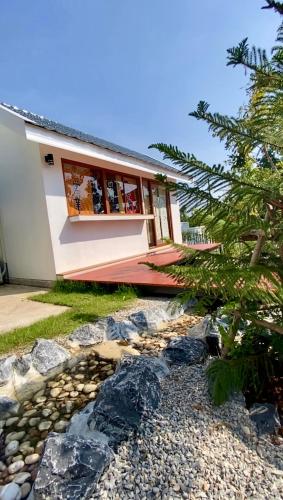 a house with a rock garden in front of it at Taka Onzen in Ban Khao Ket