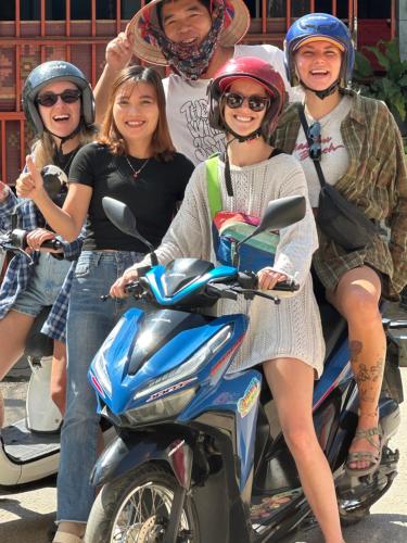 a group of people posing for a picture on a scooter at Vang vieng guesthouse in Vang Vieng