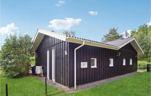 a black building with a pitched roof at Pet Friendly Home In Knebel With Sauna in Skødshoved Strand