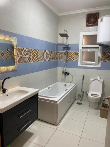 a bathroom with a tub and a sink and a toilet at Hotel Apartment New Cairo in Cairo
