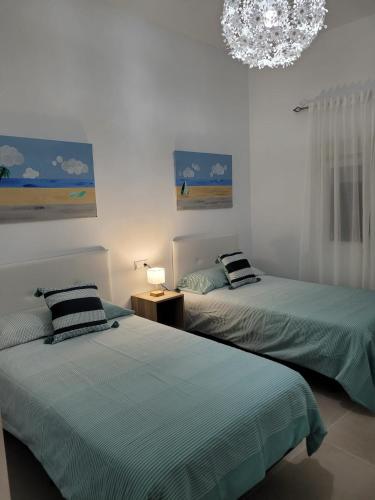 a bedroom with two beds and a chandelier at La Kasita in Arafo
