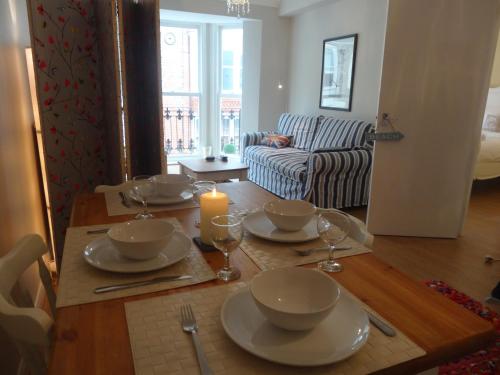 a dining room table with plates and a candle on it at Burlington Beach Apartments in Brighton & Hove
