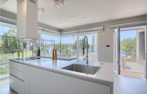 a kitchen with a sink and a large window at Villa Lunjsko in Stara Novalja