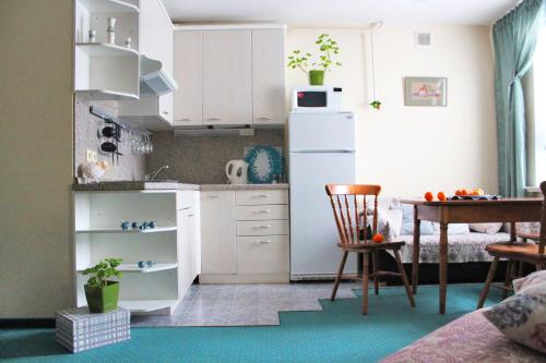 プリョスにあるMuza Apartmentsの小さなキッチン(白いキャビネット、テーブル付)