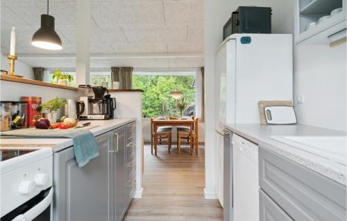 a kitchen with white appliances and a dining room with a table at Amazing Home In Gørlev With Wifi in Gørlev