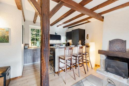 une cuisine avec une table et des tabourets de bar dans l'établissement Escapade médiévale Charme et Authenticité, à Guérande