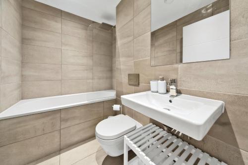 Un baño con lavabo, inodoro y espejo. en Atlas House Eight, en Harrogate