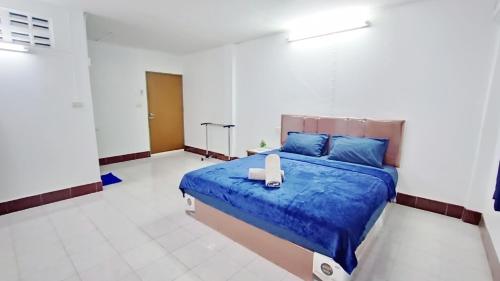 a bedroom with a bed with a blue comforter at Apartment near Central Festival Hatyai in Hat Yai