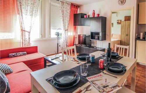 a kitchen and living room with a table with plates on it at Pet Friendly Apartment In Torremolinos in Torremolinos